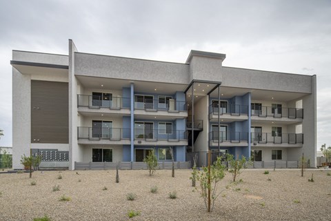 A modern building with a flat roof and a balcony on the second floor.