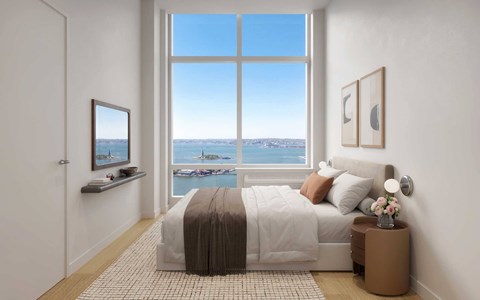 A bedroom with a large bed and a view of the water.