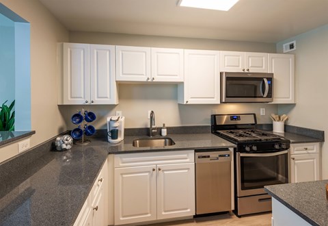 A kitchen with white cabinets and a black stove top.