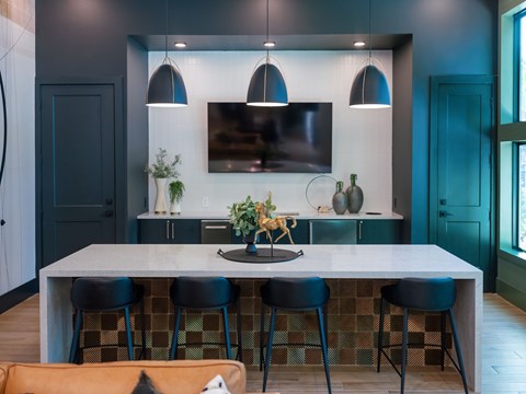 A modern kitchen with a large island and bar stools.
