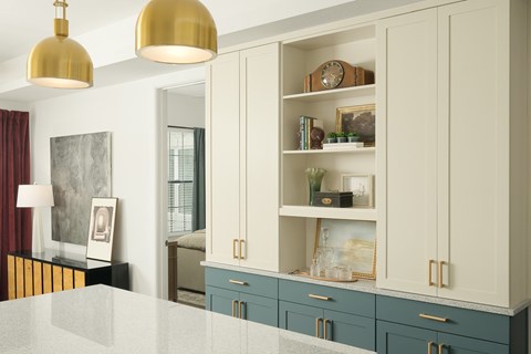 A kitchen with white cabinets and a grey counter top.
