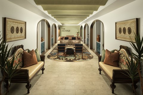A long hallway with a rug and couches on either side.