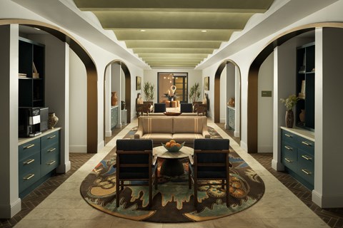 A living room with a couch, chairs, and a rug in the center.