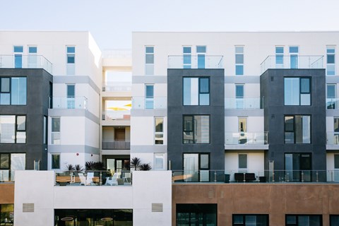 A modern apartment complex with balconies and multiple floors.