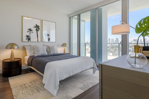 A bedroom with a large bed and a view of the city.