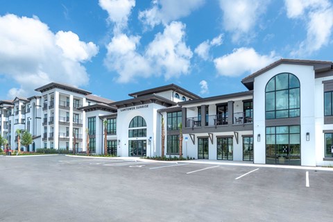 A large, modern building with a parking lot in front.