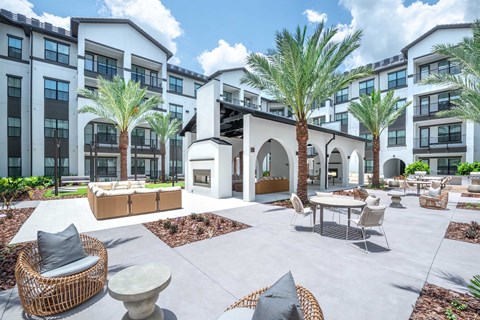 A courtyard with a white building and palm trees.