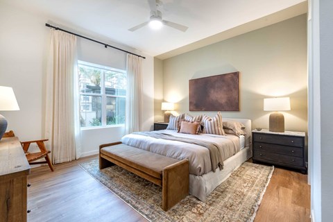 A bedroom with a large bed and a ceiling fan.