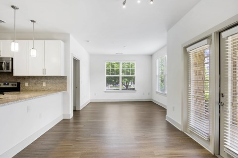 A spacious kitchen with white cabinets and a wooden countertop.
