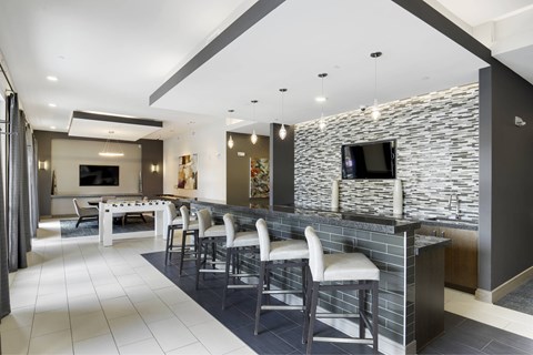 A modern living room with a stone wall and a bar area.