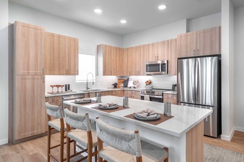 A modern kitchen with wooden cabinets and a white island.