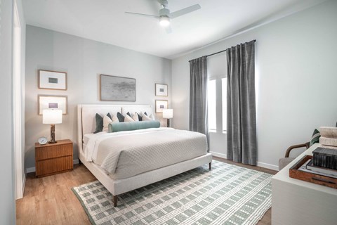 A bedroom with a large bed and a ceiling fan.