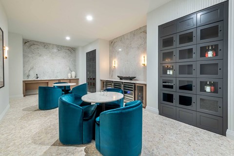 A modern dining room with a round table and teal chairs.