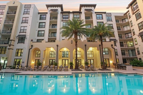 A large building with a pool in front of it.