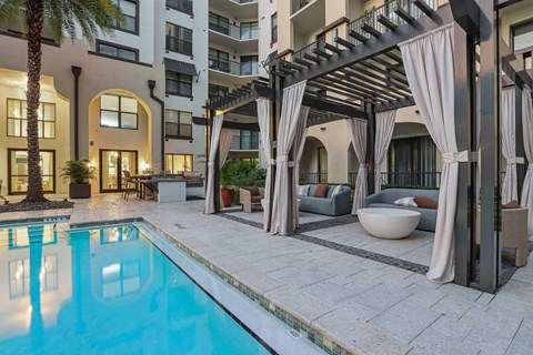 A pool area with a pergola and seating area.