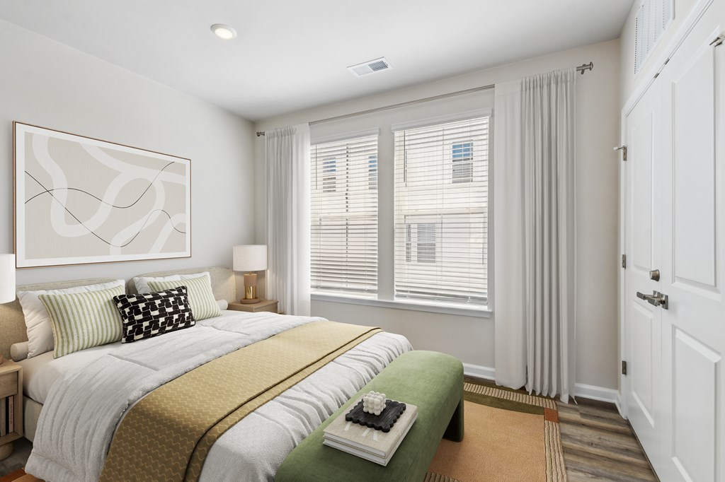 A bedroom with a large bed and a painting on the wall.