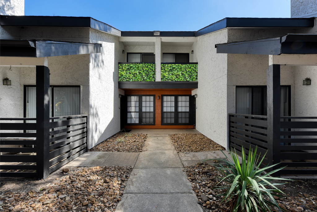 a house with a green hedge on the top of the house