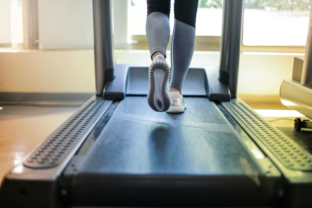 a woman running on a treadmill in a gym