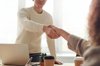 two people shaking hands in a meeting room