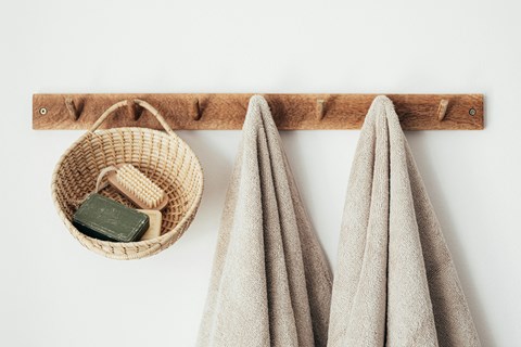 a wooden shelf with two towels and a basket on it