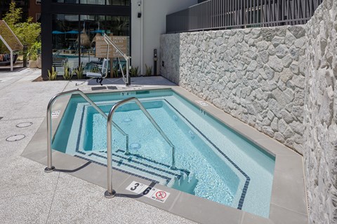 A small pool with a glass barrier and a no swimming sign.