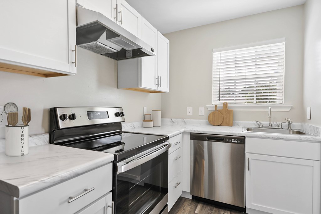Modern kitchen with white cabinets and stainless steel appliances at Pooler Station apartments for rent in Pooler, GA.