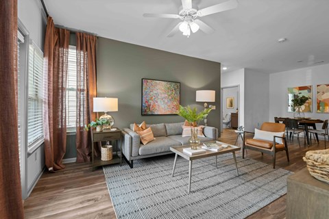 A living room with a grey sofa, a coffee table, and a painting on the wall.