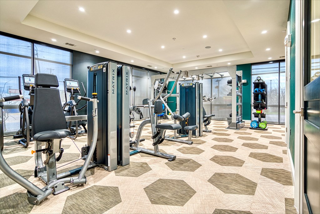 a gym with cardio machines and weights on the floor