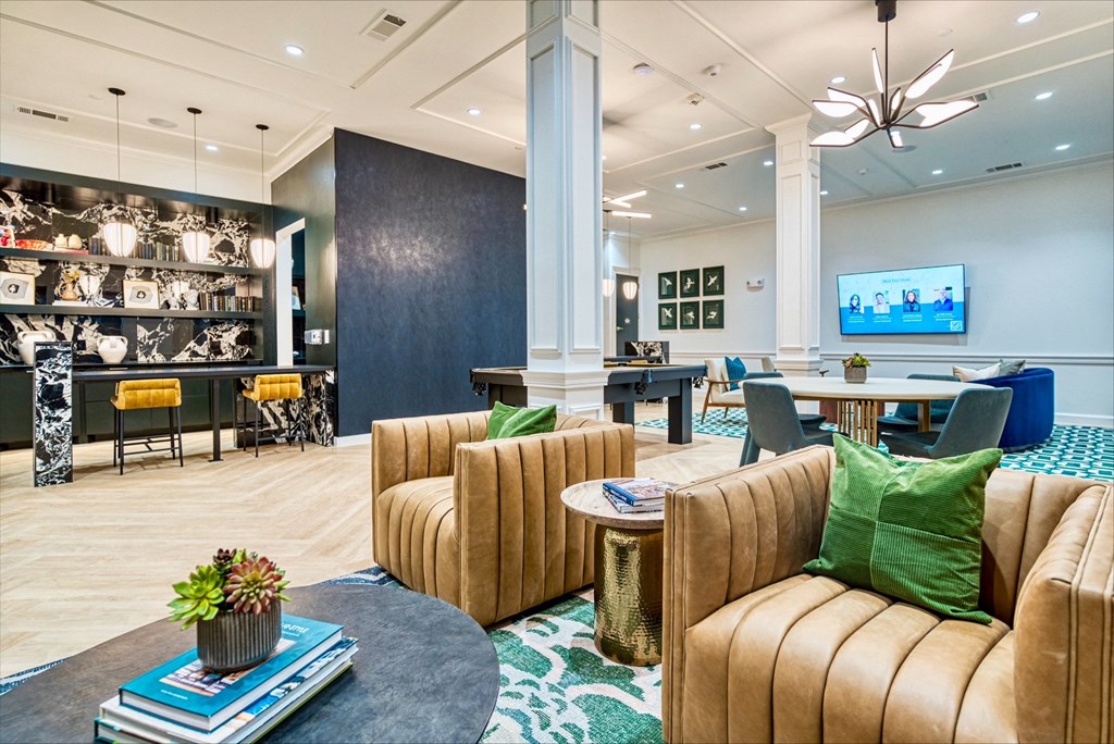 a lobby with couches chairs and tables and a tv