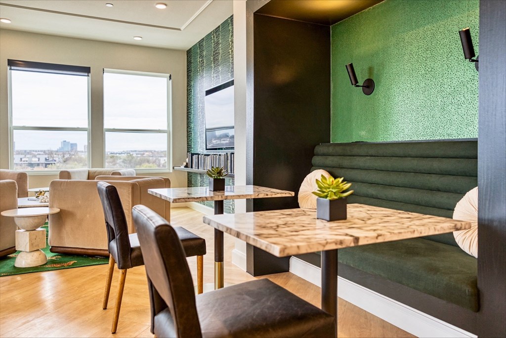 a dining room with tables and chairs and a green wall