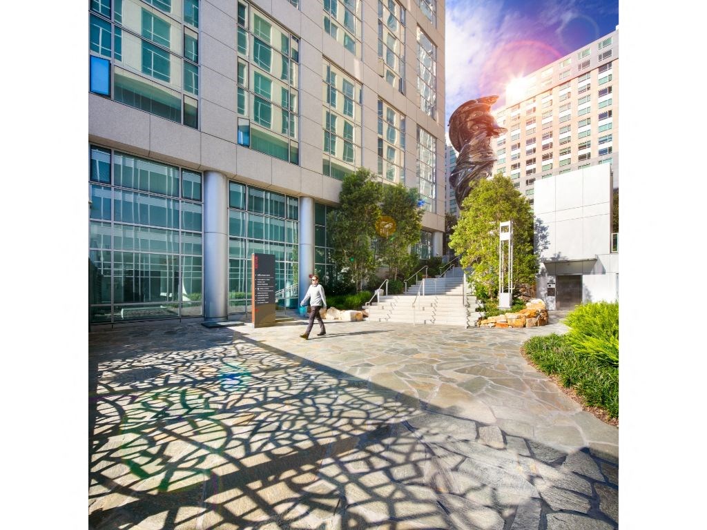 a man walking in front of a tall building