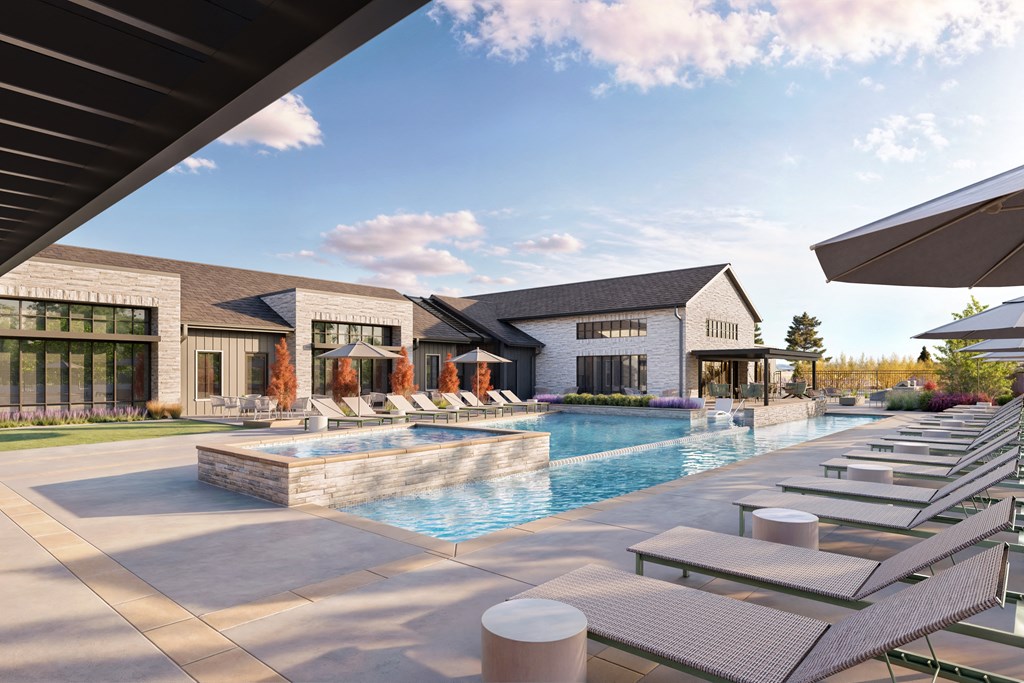 a swimming pool with lounge chairs in front of a house