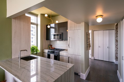 a kitchen with white cabinets and a marble counter top