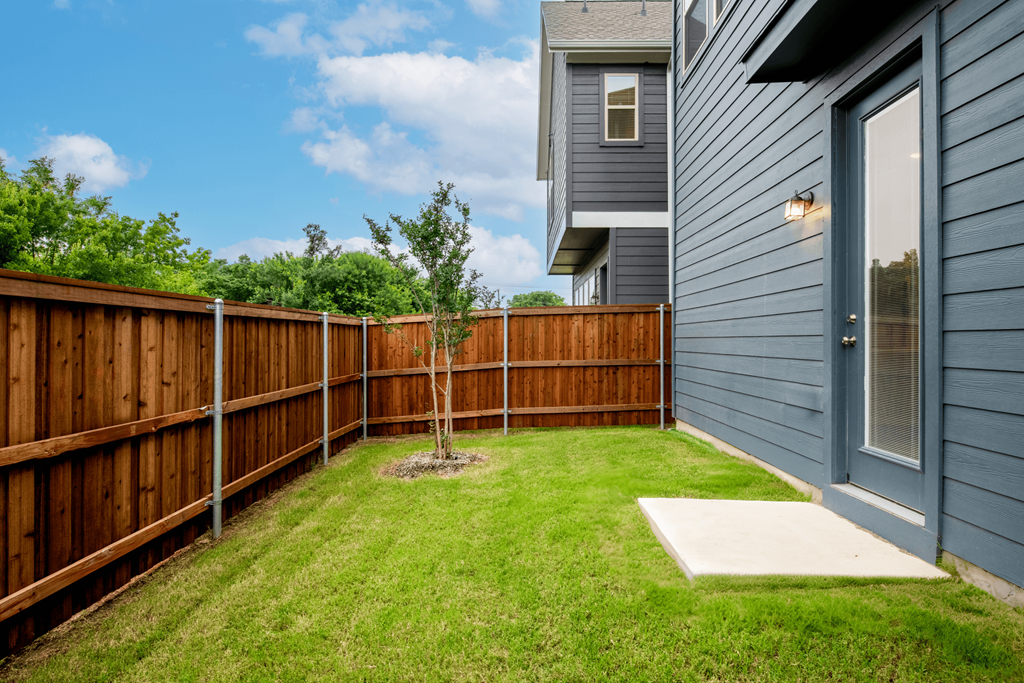 a backyard with a wooden fence and a house