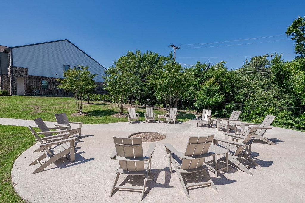 a patio with chairs and a fire pit