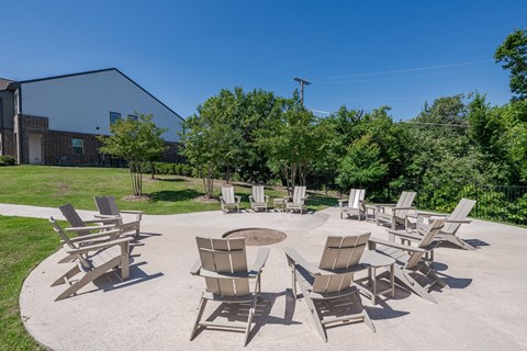 a patio with chairs and a fire pit