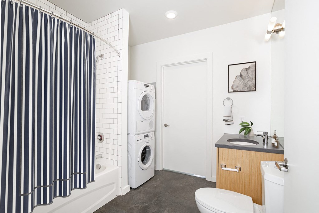 a bathroom with a washing machine and a toilet