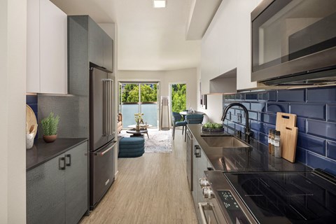 a kitchen with stainless steel appliances and a black counter top