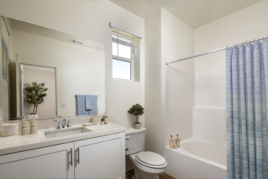 a white bathroom with a shower and a sink and a toilet