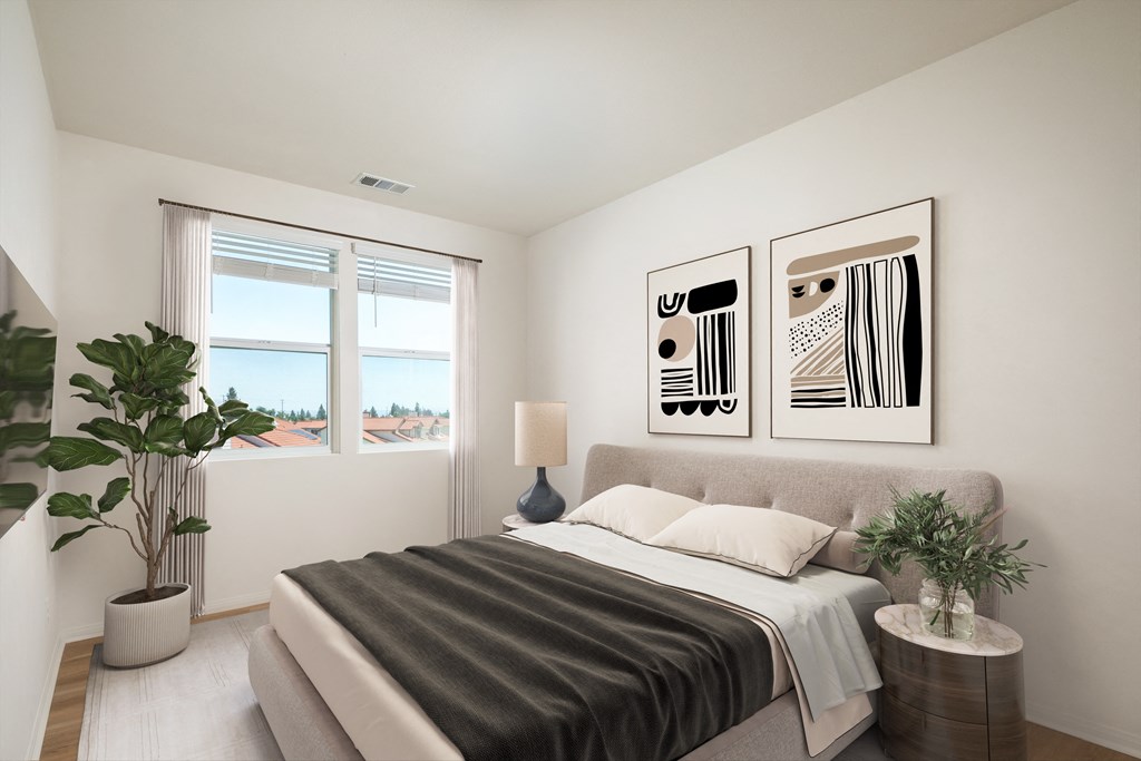 a bedroom with white walls and a bed with a gray blanket