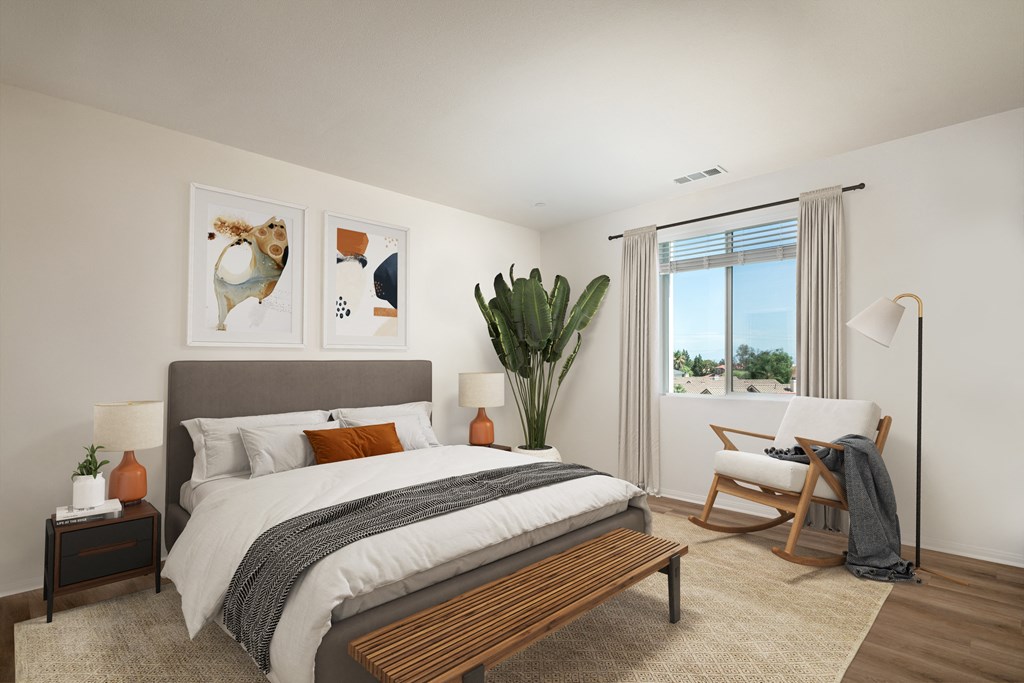 a bedroom with a bed and a chair and a window