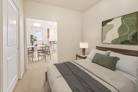 A bedroom with a large bed and a painting on the wall.