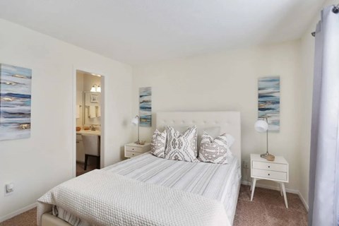 A bedroom with a large bed and a painting on the wall.