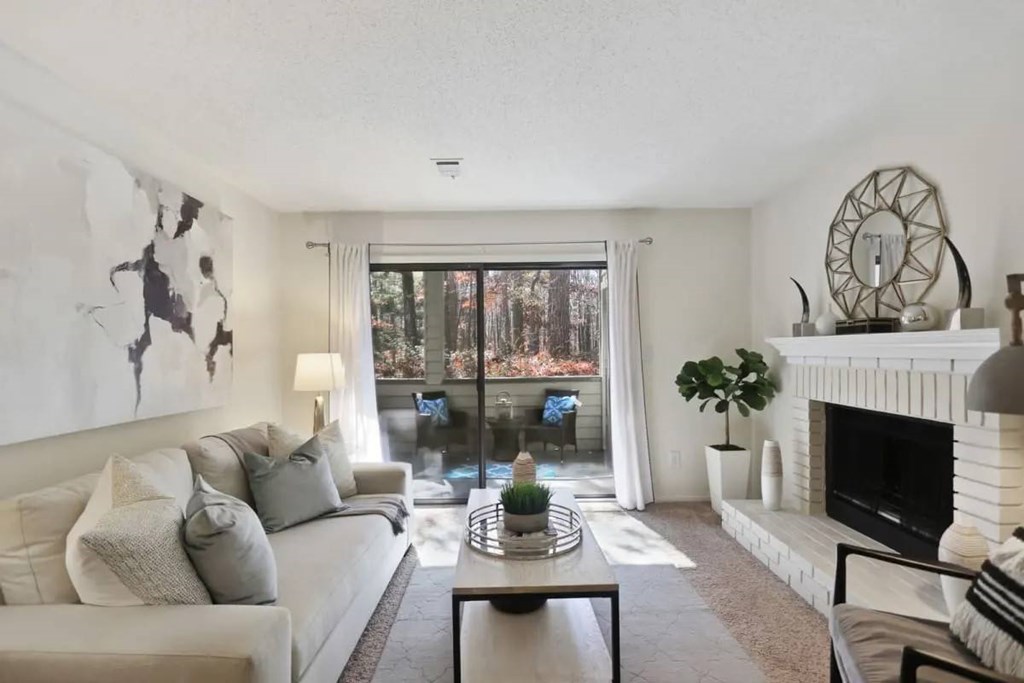 A living room with a couch, coffee table, and a fireplace.