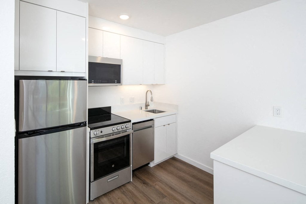 a kitchen with white cabinetry and stainless steel appliances