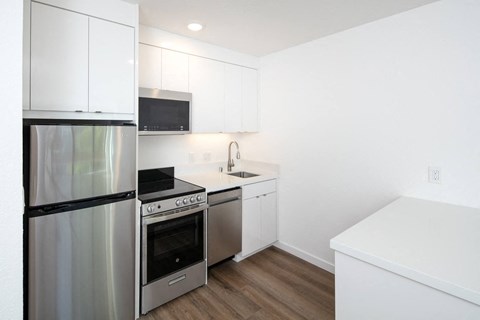 a kitchen with white cabinetry and stainless steel appliances