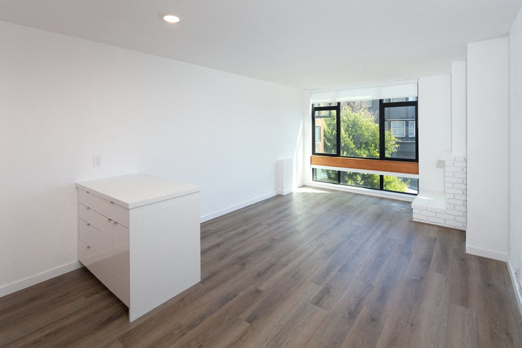 an empty room with white walls and a large window