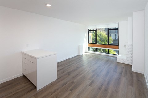 an empty room with white walls and a large window