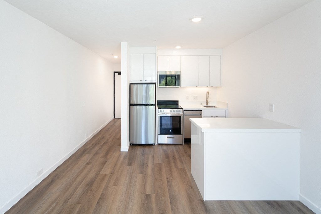 a kitchen with white cabinetry and a wooden floor