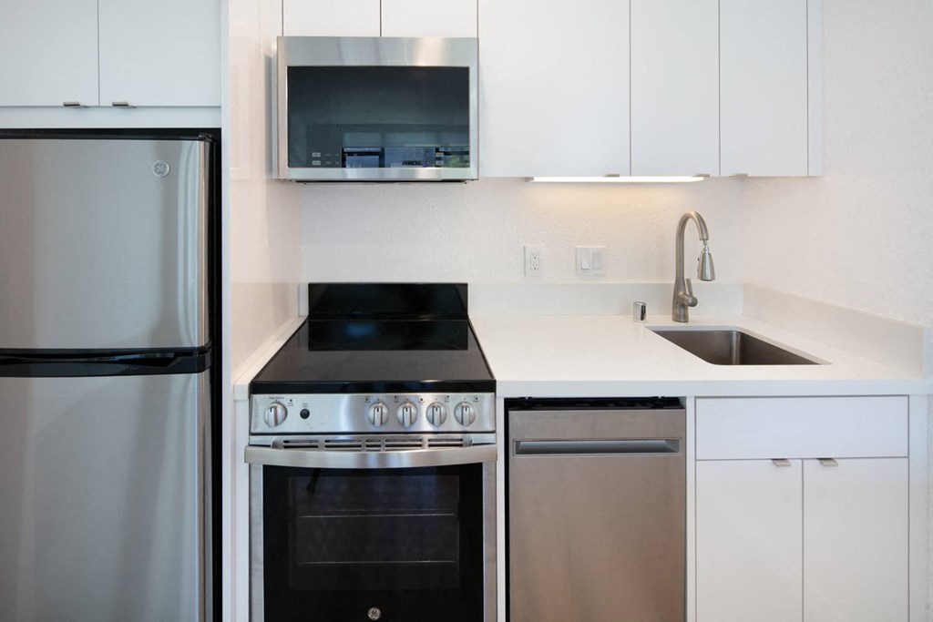 a kitchen with white cabinets and stainless steel appliances